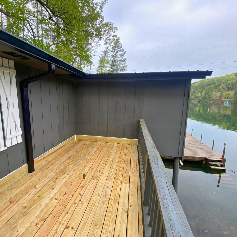 New deck on back of gray house with white southern shutters